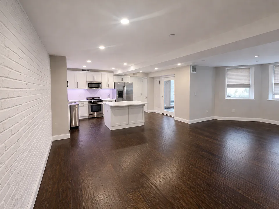 View of the living room, dining room and kitchen from the main building entrance.
