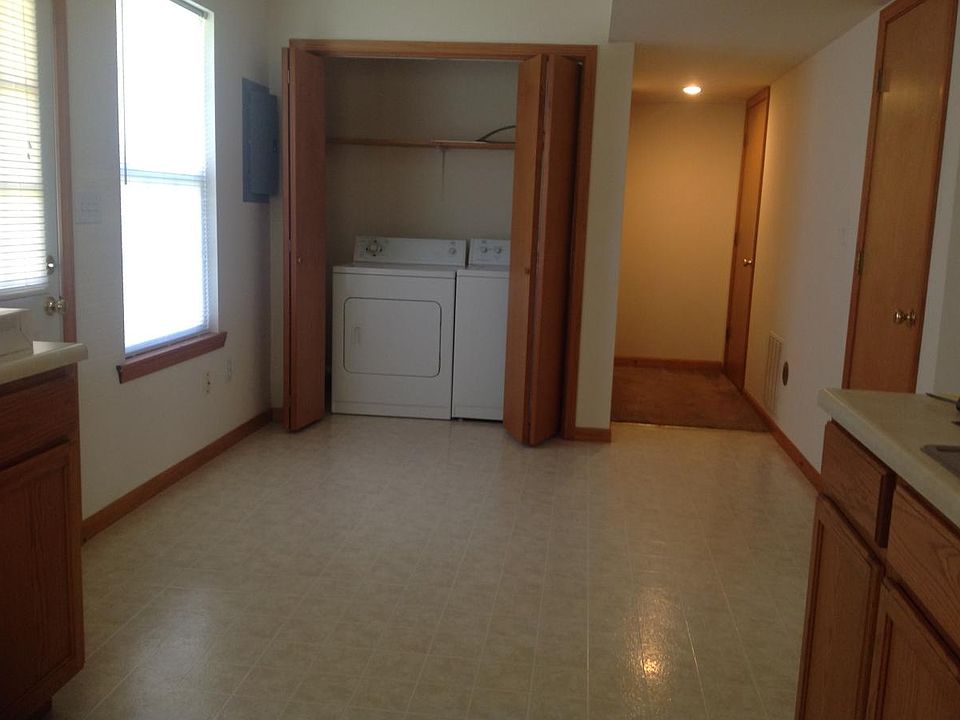 Looking from kitchen, dining area, pantry, 1/2 Bathroom, storage closet with shelves at end of the hall, laundry at end of the dining area.