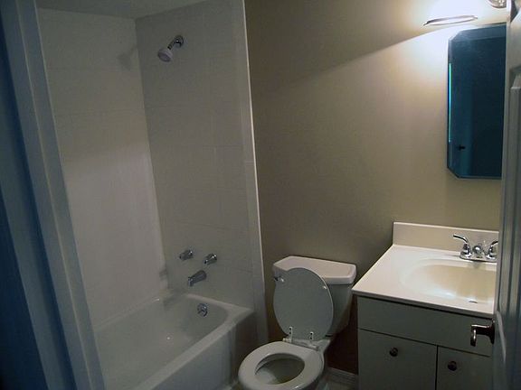 Bath with new cabinets, retiled with white tile.  Also has a linen closet.