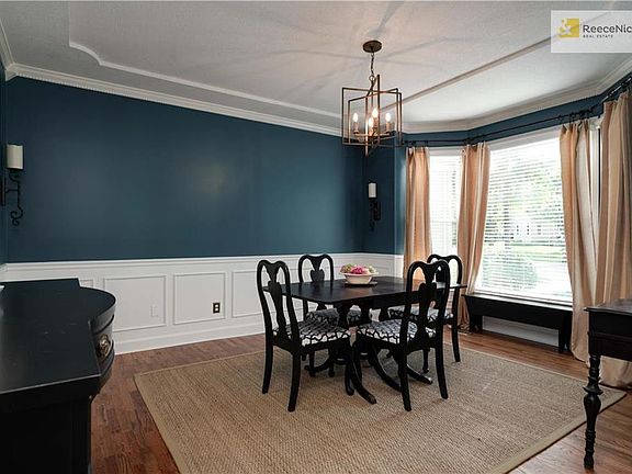 Dining Room w/ hardwood flooring and wainscoting.