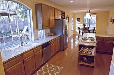 Large kitchen with oversized windows looking out to yard.  Hardw