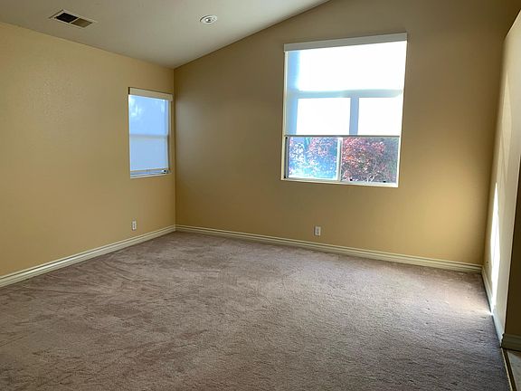 spacious primary bedroom with high ceiling and plenty of light.