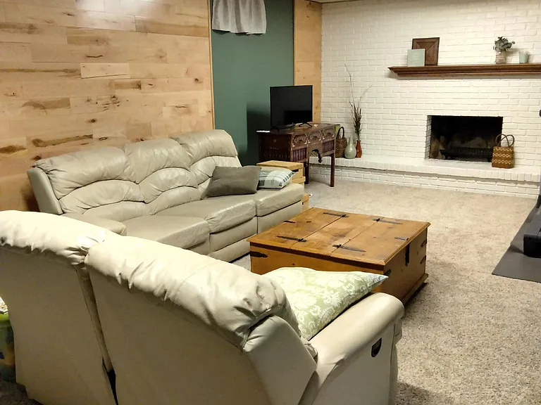 large finished basement includes play or lounge area, full bath with tub, bedroom with wood floors, double-size carpeted bedroom, storage & utility room