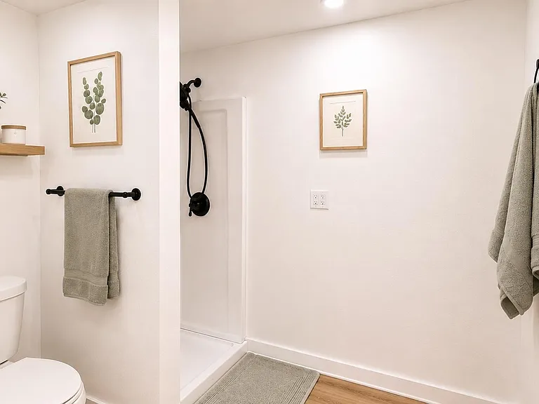 Clean bathroom featuring a walk-in shower with matte-black fixtures.
Image is virtually staged.