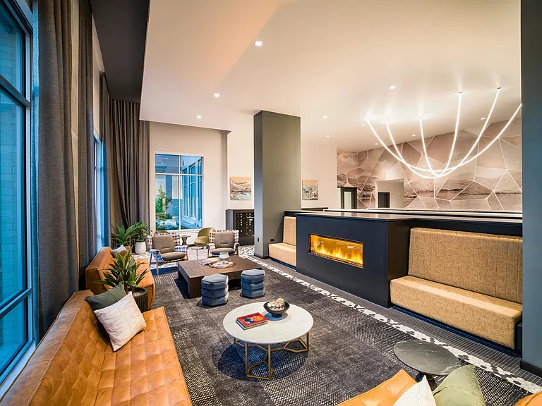 Warm tones and modern finishes create an inviting lounge at Modera Shoreline_perfect for connecting with neighbors or relaxing fireside.