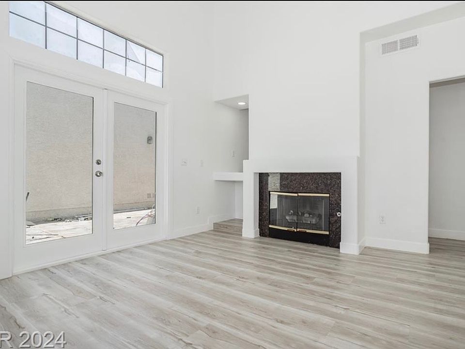 entryway, living room with fireplace and backyard access/ mini bar area