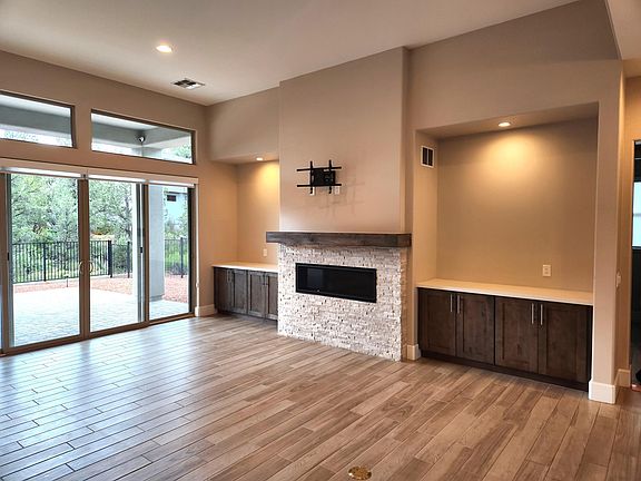 Beautiful fireplace flanked by custom storage cabinets plus lighted galley wall above