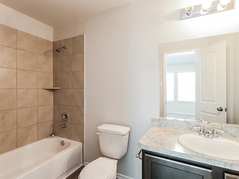 Modern bathroom featuring elegant tile work, a sleek vanity with a granite countertop, and ample natural light. Modern bathroom featuring elegant tile work, a sleek vanity with a granite countertop, and ample natural light.