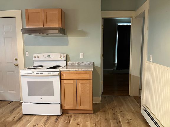 opposite view of kitchen, showing back door to hall going to back porch and basement, and open doorways to pantry and back bedroom