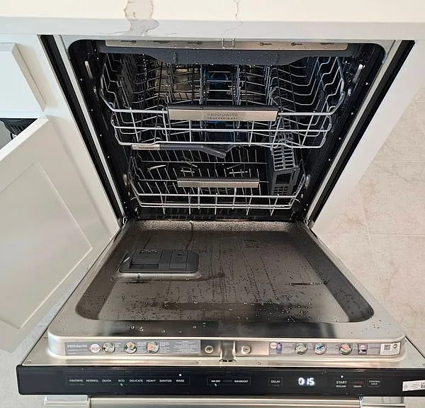 Kitchen view of dishwashing machine and stone countertops