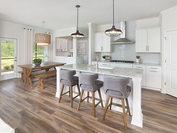 The kitchen flows seamlessly into the cafe as natural light from the nearby window illuminates the r