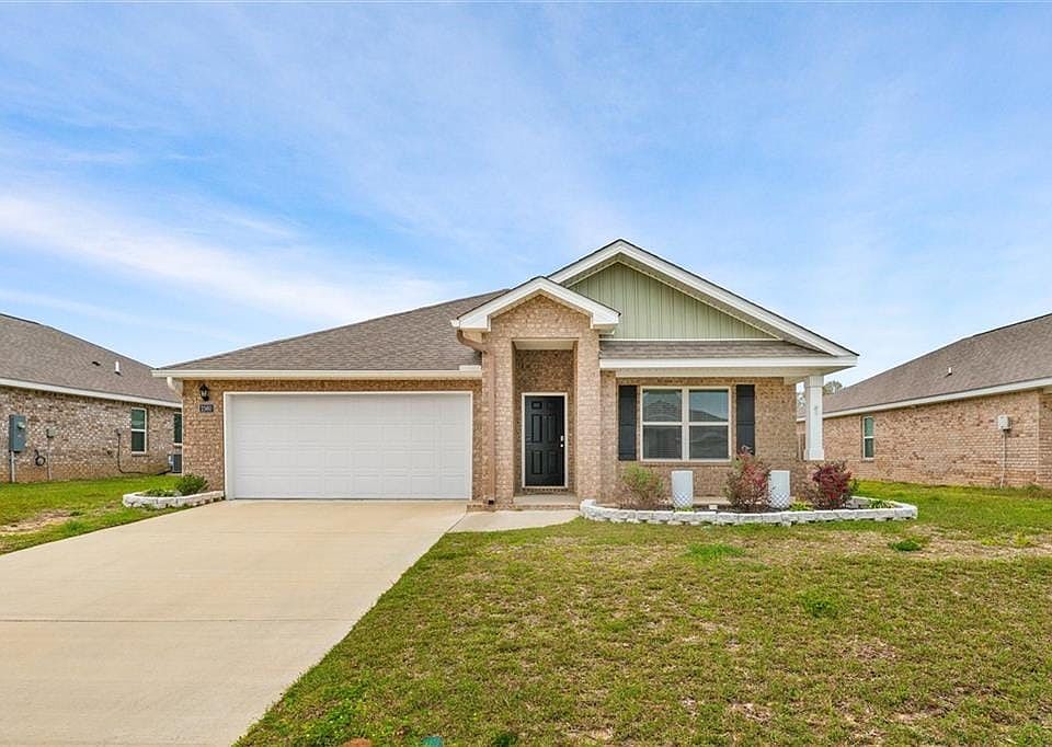 View of front of home with a garage and a front lawn