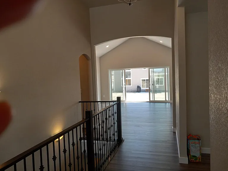 Looking thru breezeway to arched opening into the Great Room. Double-wide glass patio door (12 feet wide) opening onto 30-by-16 foot concrete patio.