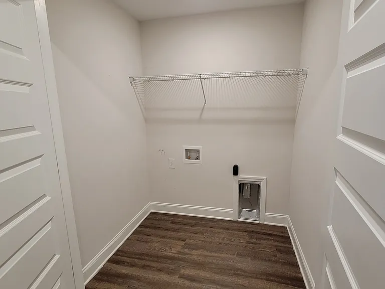 Laundry room with needed connections and clothes hanging/storage rack