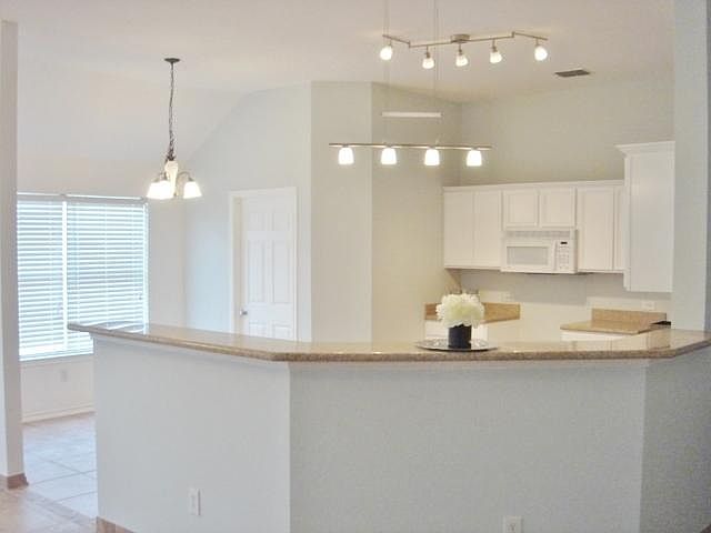 white kitchen, granite counters & what a fixture!