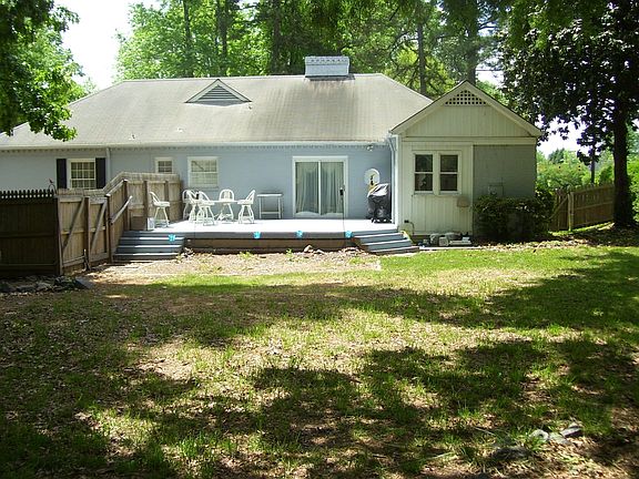 Large fenced yard with shade trees