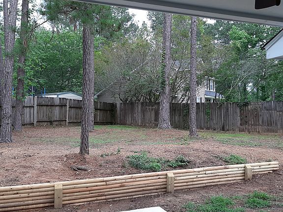 Large fenced yard in back with newly built retaining wall