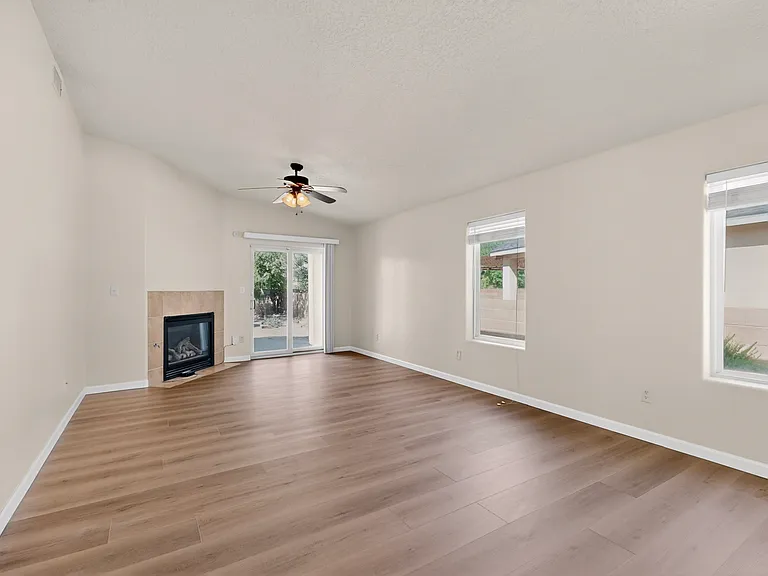 Expansive open concept living room with plenty of natural light from the two windows, gas fireplace and dining area directly off the kitchen. Vaulted ceilings give the space elegance.