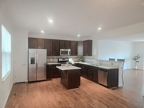 Open concept kitchen with granite counters, SS appliances and pantry. Opens into the Dining room