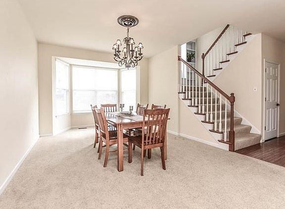 Formal dining room with elegant chandelier and bay window.
