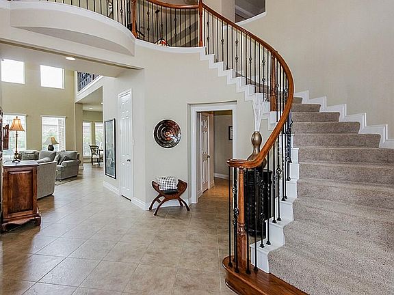 Sweeping staircase with wrought iron balusters.