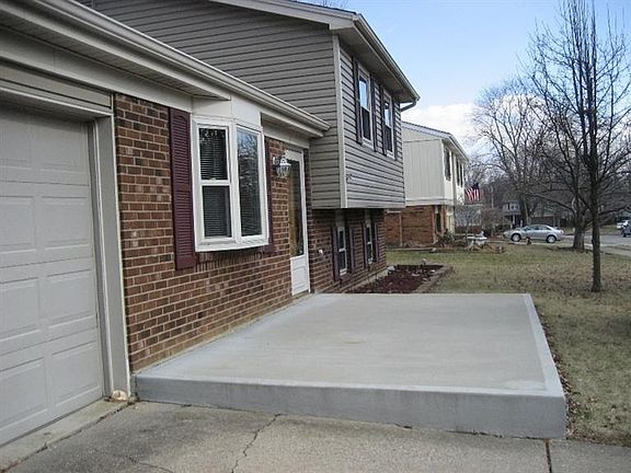 New concrete front porch expanded to display outdoor furniture.