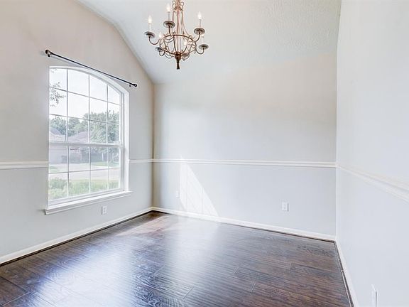 As you enter the home, the formal dining room is to the left.  Freshly painted, laminate wood flooring, elegant light fixture and chair rails enhance this room.