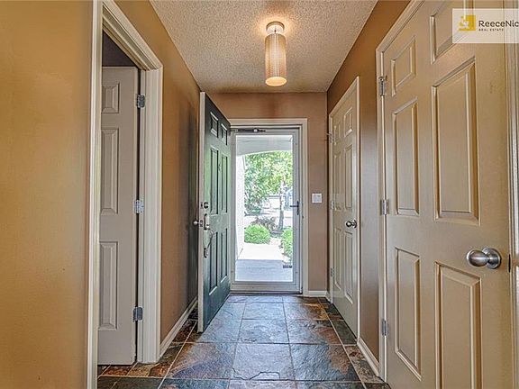 Entry way has slate tile and half bath to the right of front door.