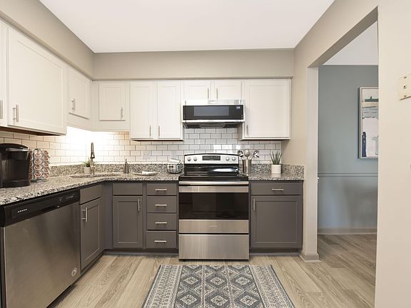 Kitchen with granite counters, stainless appliances, and two-tone modern cabinetry