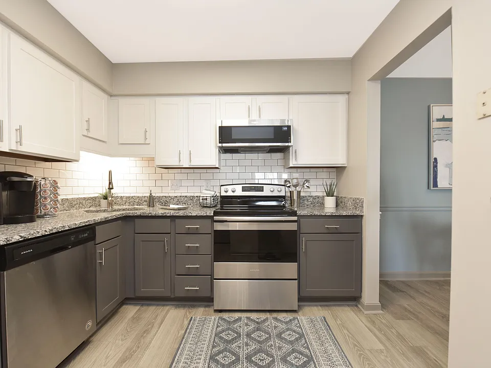 Kitchen with granite counters, stainless appliances, and two-tone modern cabinetry