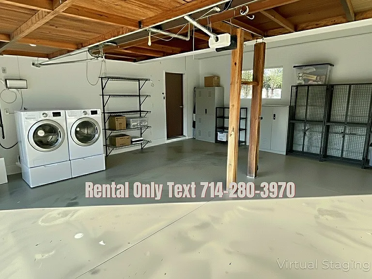Enhanced photo of 30242 Via Borica. Garage where laundry is located that fits 2 cars and there is plenty of driveway space as well.