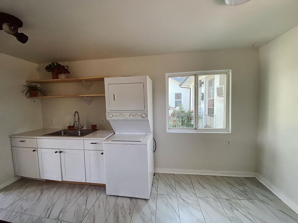 Stackable washer in-unit with space for a dining table and seating.