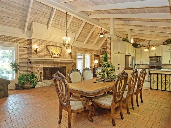 Dining area with over-sized fireplace open to kitchen.
