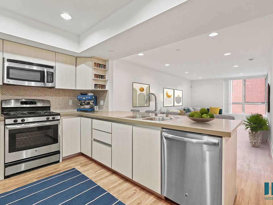 Open-concept kitchen, with Stainless-Steel Refrigerator, Stove, Microwave Oven, Dishwasher, and Countertop Bar