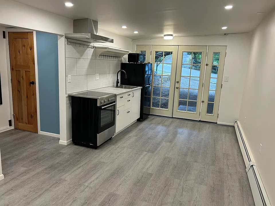 Front door, kitchenette, wooden door accesses full bath