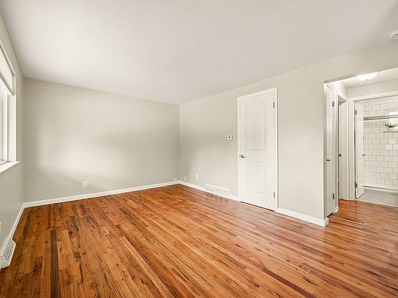 Step into a living room filled with natural light and gleaming hardwood floors.
