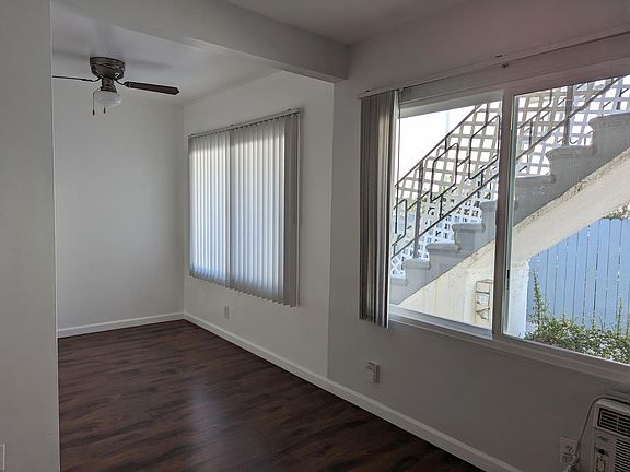 View from the living room looking out towards the balcony, stairs, and driveway.