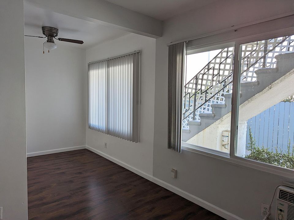 View from the living room looking out towards the balcony, stairs, and driveway.