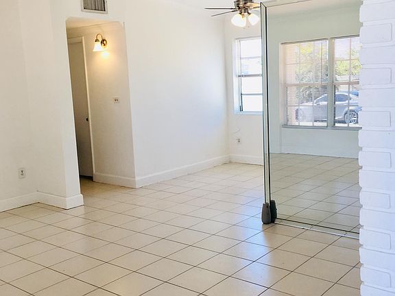 Bright entry into living room and dining area, well lit with natural light and window blinds for privacy