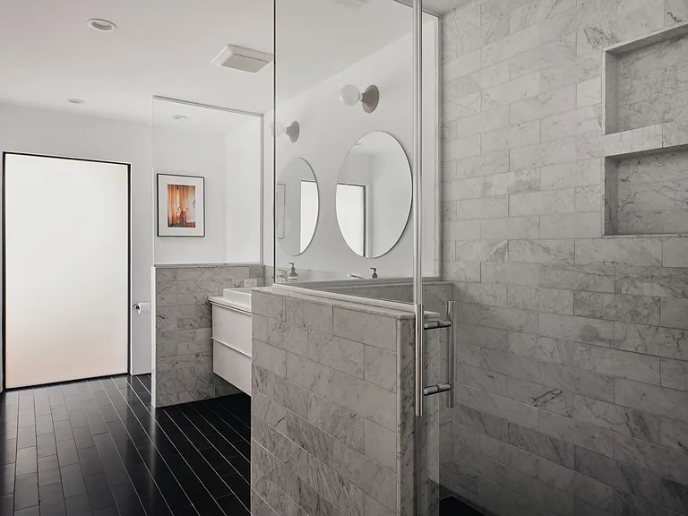 Secondary bathroom with duel vanity, marble throughout and high-end Toto toilet system.