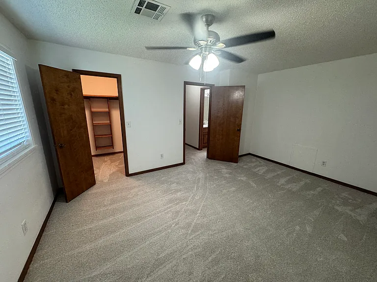 Third bedroom with large walk-in closet and ceiling fan