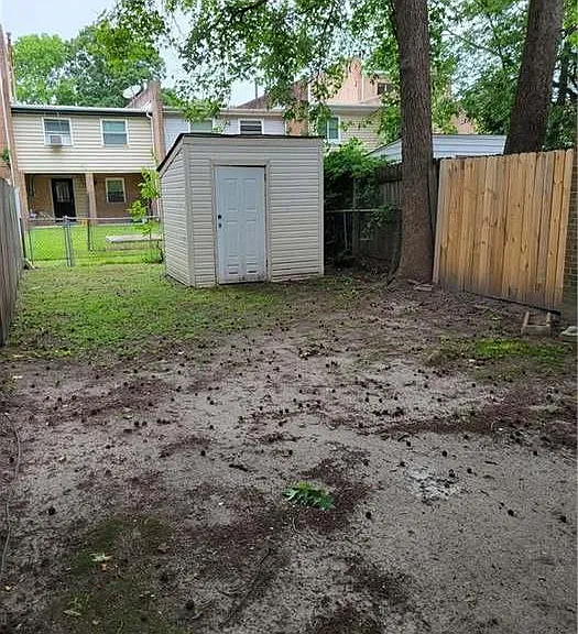fenced in backyard with gate access to back neighbor area and with storage shed for gardening equipment
