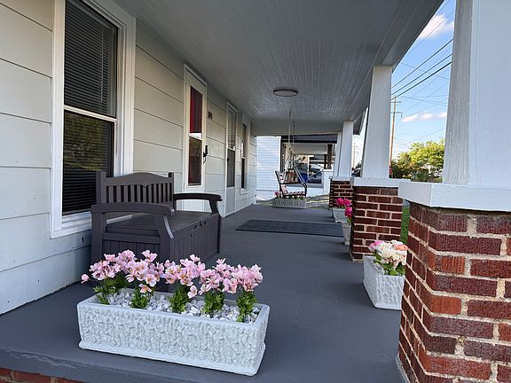 Large covered front porch with swing and bench