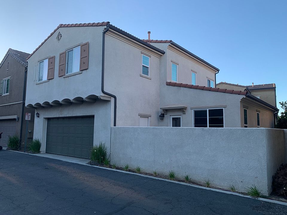 Back of the house with an attached garage and backyard patio.