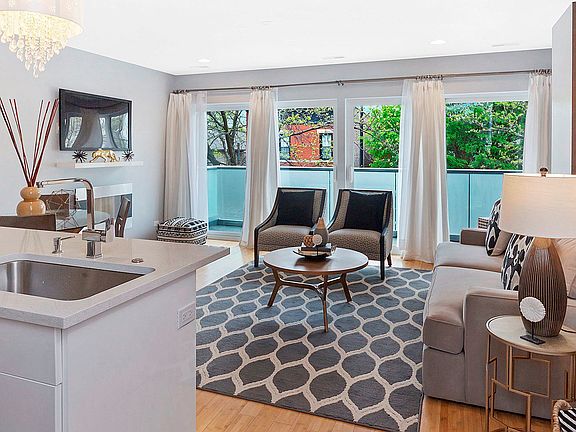 Bright & airy south facing living room/ dining room w/floor to ceiling doors and windows which leads