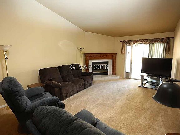 Living room with fireplace, opens to dining and kitchen area. Slider to backyard.
