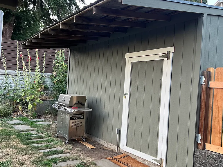 Storage shed with interior lights, gravel floor.