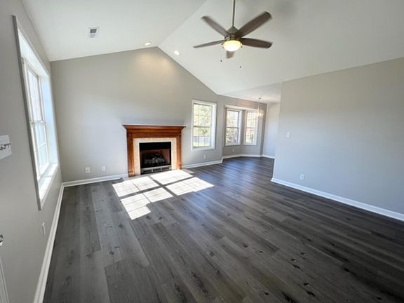 Open living room with fireplace, vaulted ceilings and new flooring