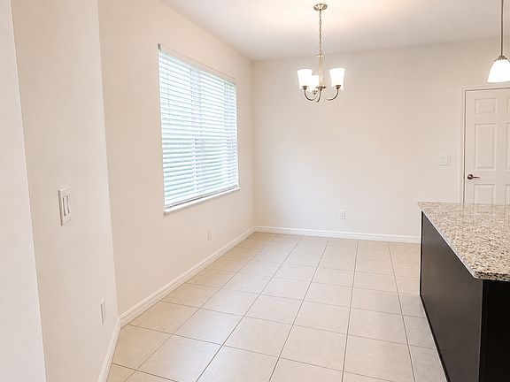 Bright dining space overlooking the entrance pathway with easy access to the garage and covered lanai.