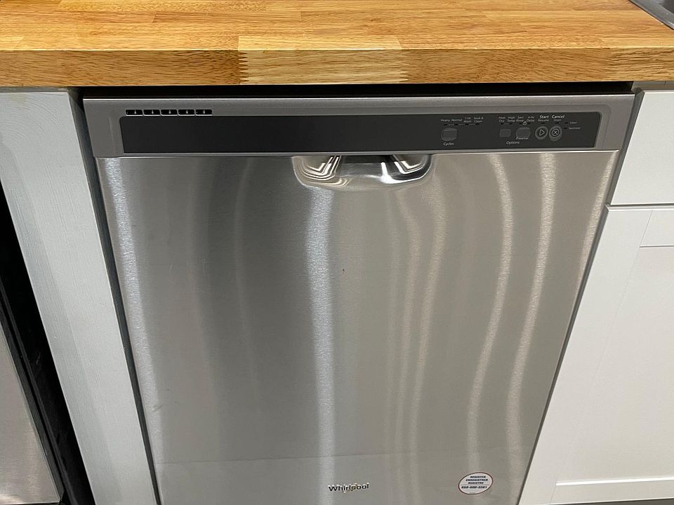 Oiled butcher block countertops and stainless steel dishwasher.